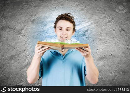 Man with book. Young man in casual holding opened book with windmills