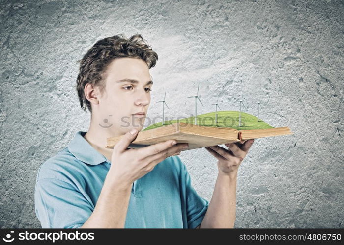 Man with book. Young man in casual holding opened book with windmills