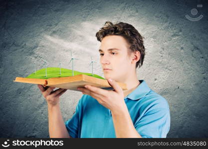 Man with book. Young man in casual holding opened book with windmills