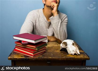 Man with books and animal skull