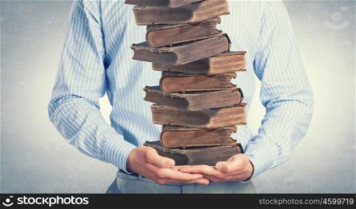 Man with books. Close up of man holding pile of books in hands