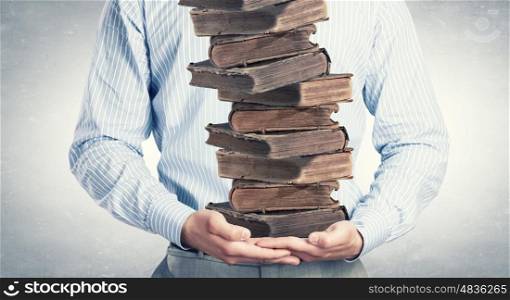 Man with books. Close up of man holding pile of books in hands
