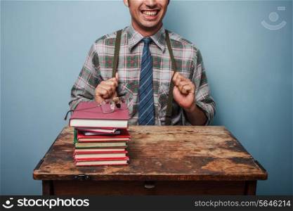 Man with books sitting at an old desk
