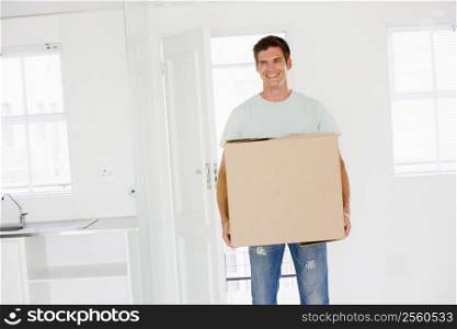 Man with box moving into new home smiling