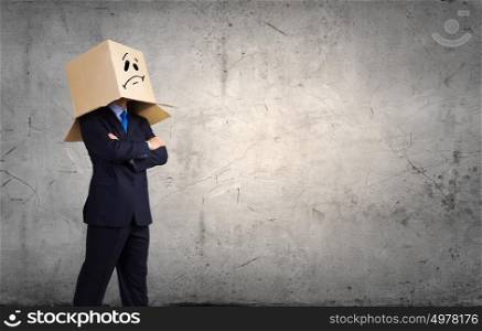 Man with box on head. Unrecognizable businessman in suit wearing carton box on head