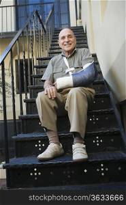 Man with broken arm sitting on stairs