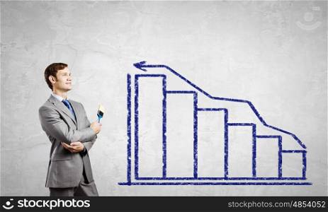 Man with brush. Young businessman painting graphs and diagrams with brush