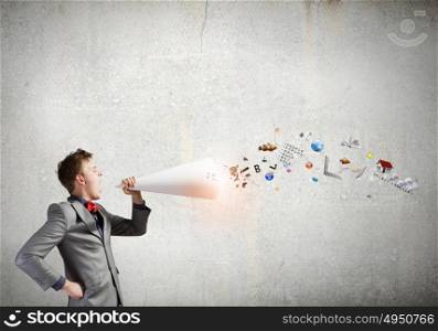 Man with bullhorn. Young businessman speaking in trumpet and colorful icons flying out