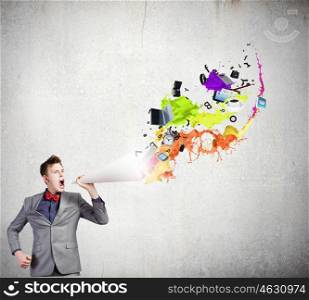 Man with bullhorn. Young businessman speaking in trumpet and colorful splashes flying out