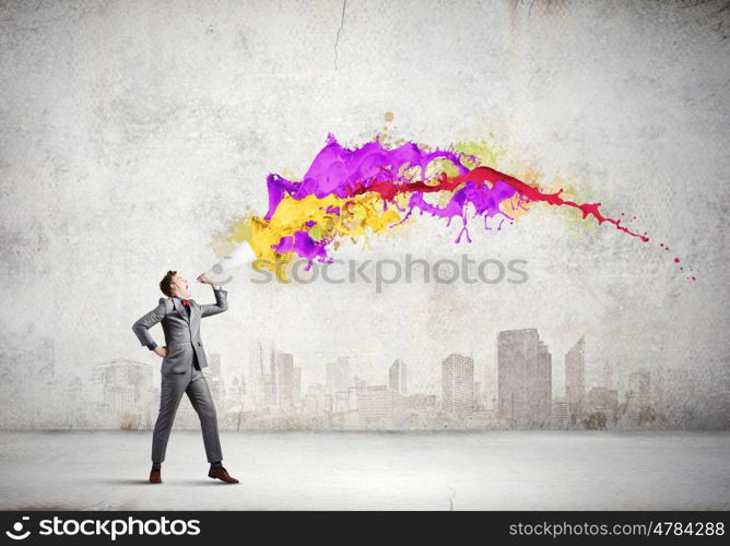 Man with bullhorn. Young businessman speaking in trumpet and colorful splashes flying out
