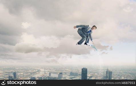 Man with can. Young businessman standing on cloud and watering something below