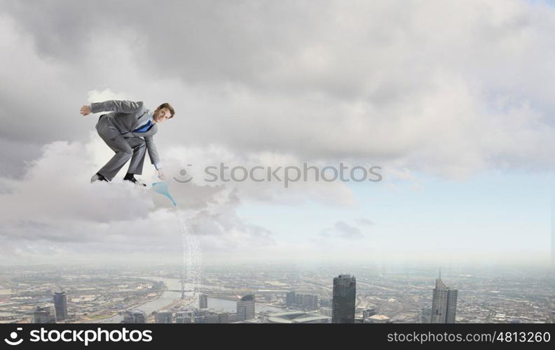 Man with can. Young businessman standing on cloud and watering something below