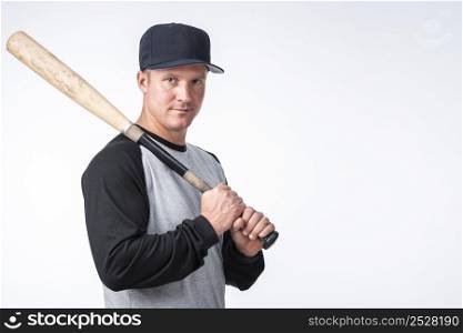 man with cap posing with baseball bat