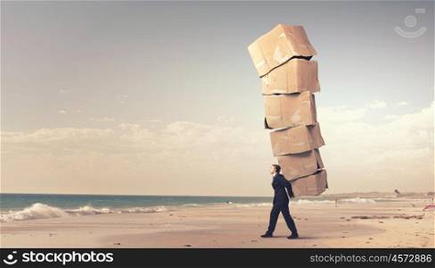Man with carton boxes. Businessman carrying big stack of carton boxes