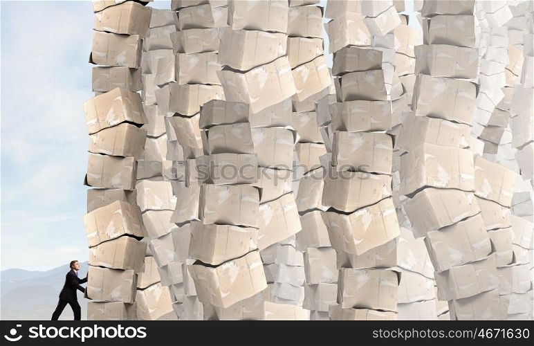 Man with carton boxes. Businessman trying to move big stack of carton boxes