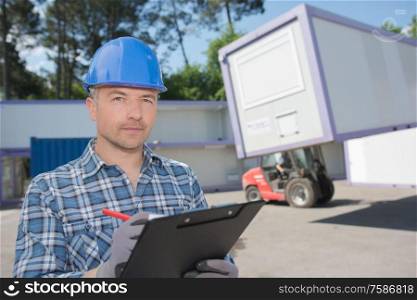 Man with clipboard wearing hardhat