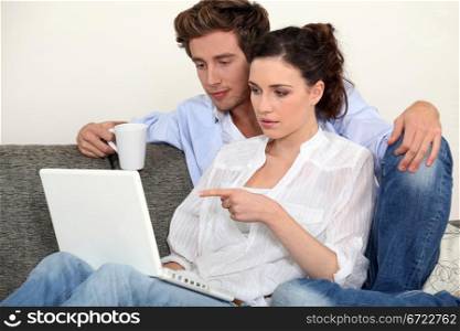 Man with coffee and woman in front of notebook