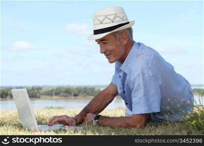 Man with computer at edge of river
