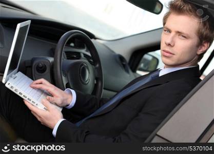 Man with computer in car