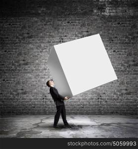 Man with cube. Young businessman carrying white blank cube. Place for text