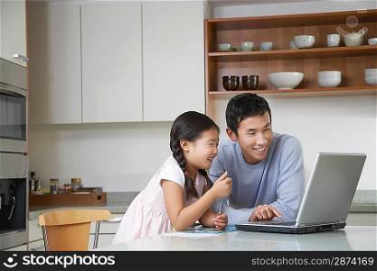Man with Daughter Enjoying Themselves with Laptop