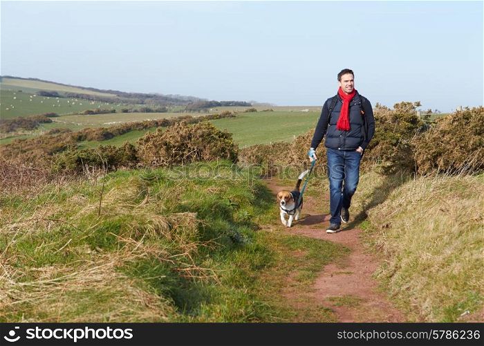 Man With Dog Walking Along Coastal Path
