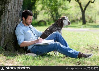 man with dog with white blank on green park grass