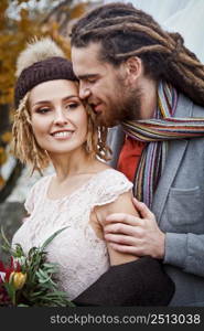 Man with dreadlocks hugging his bride. Newlyweds posing in love at the wedding. Married couple concept.