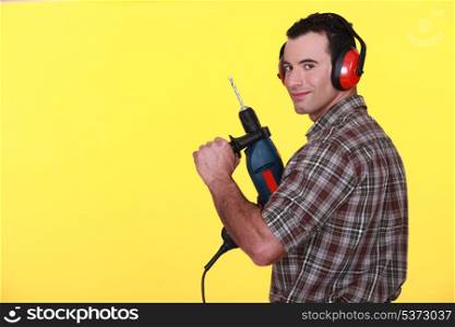 Man with drill and earmuffs