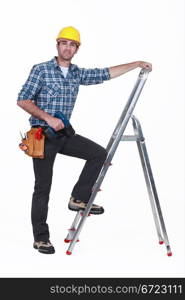 Man with drill climbing ladder