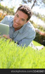 Man with electronic tablet in public park
