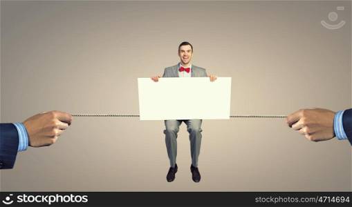 Man with empty banner. Young businessman sitting on rope holding white blank banner