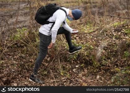 man with face mask walking through woods