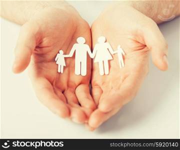 man with family of paper men. man hands showing family of paper men