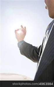 Man with fingers around sunlight