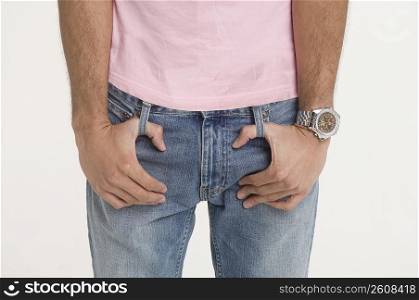 Man with fingers looped in belt loops