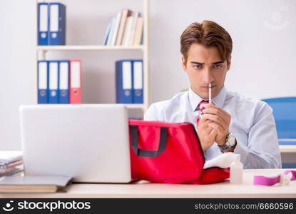 Man with first aid kit in the office