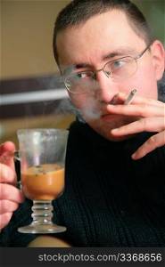 man with glass of drink and cigarette