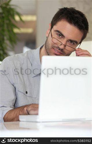 Man with glasses in front of computer