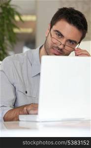 Man with glasses in front of computer