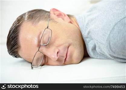 man with glasses sleeping on a desk