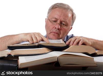 Man with glasses working with many books