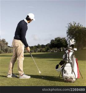 man with golf club field playing