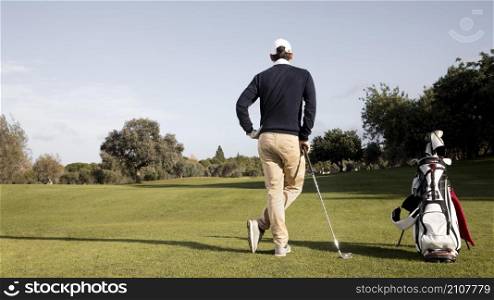 man with golf clubs copy space field