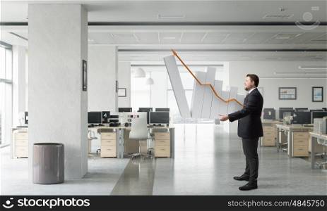 Man with growing graph. Businessman carrying graph bar growing concept in hands