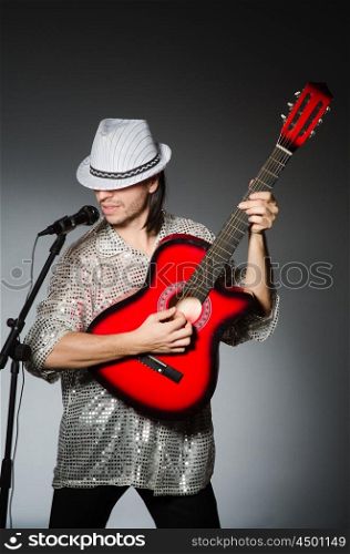 Man with guitar singing with microphone