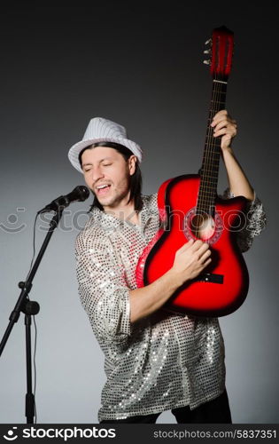 Man with guitar singing with microphone