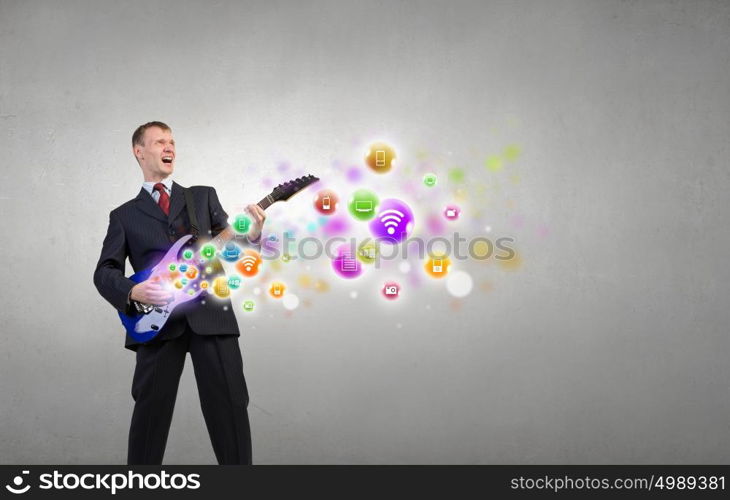 Man with guitar. Young man in black suit playing electric guitar