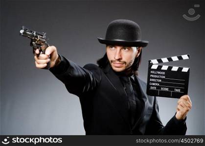Man with gun and movie clapboard