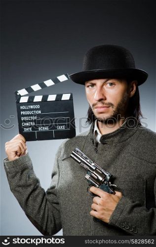 Man with gun and movie clapboard